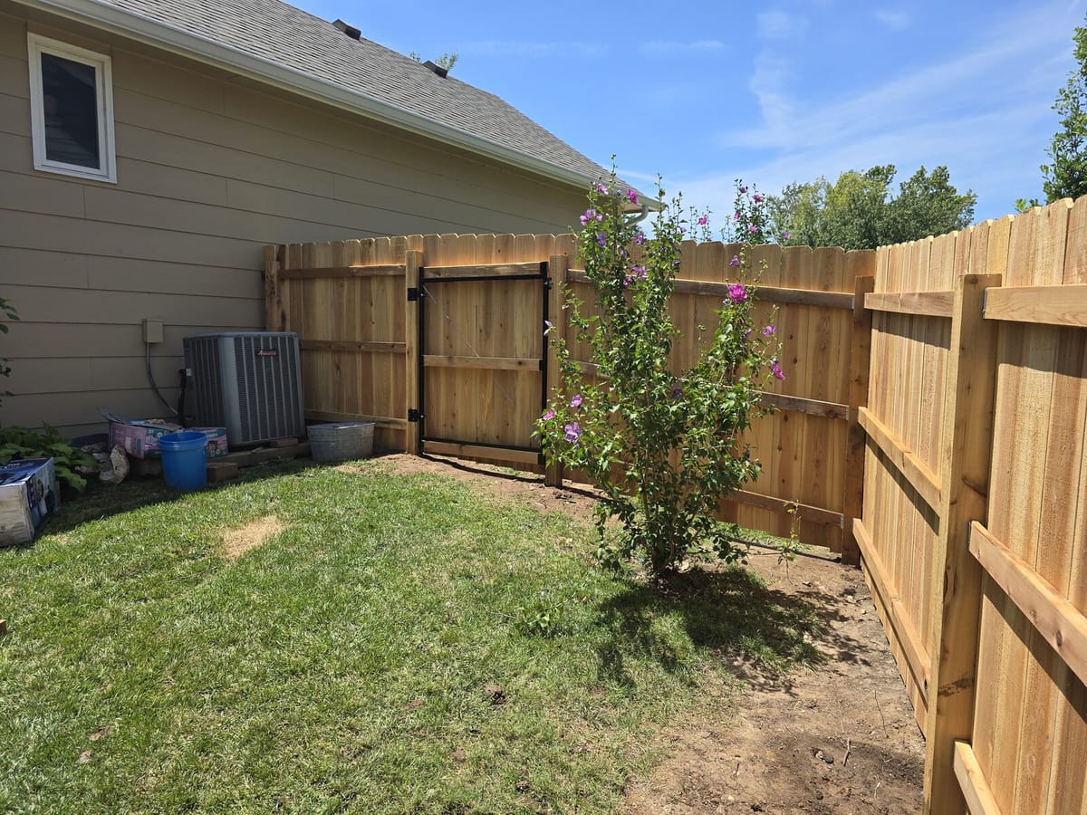Cedar walk-through gate installed in a Wichita backyard fence with heavy-duty black hardware