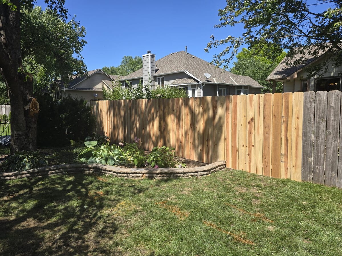 Newly rebuilt cedar fence after storm-damage repair in a Wichita backyard
