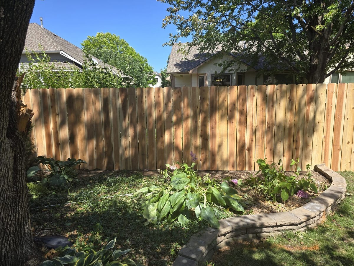 Wide shot of newly built cedar fence replacing the storm-damaged section